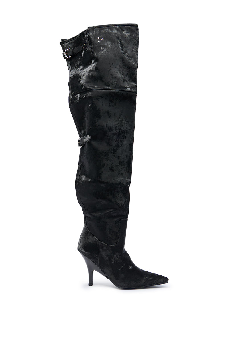 The AZALEA WANG BACKER BLACK SHINE OVER THE KNEE BOOT features a pointed toe, mid-height stiletto heel, buckle strap details at the upper and mid-calf, and a slightly slouched silhouette for modern edge.
