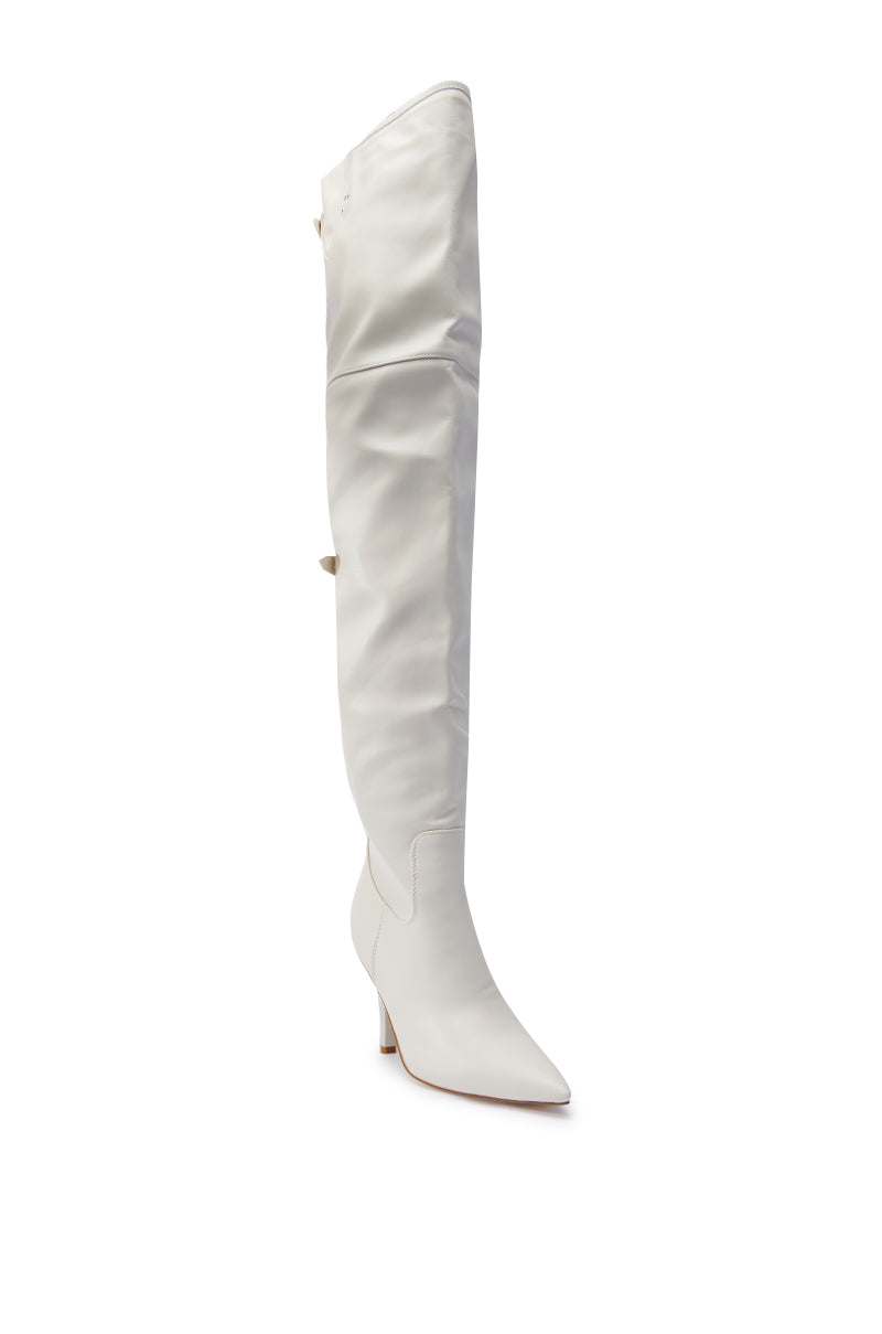 The AZALEA WANG BACKER BONE OVER THE KNEE BOOT is displayed against a white background, showcasing a sleek design with a single pointed toe and mid-height stiletto heel. The faux leather boot features a slightly slouched upper, exuding modern elegance.