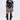 A woman stands confidently in the BOUJEE BANDANA SEQUIN MINI DRESS IN BLACK, styled with layered necklaces, large hoop earrings, and knee-high black patent boots featuring multiple buckles.