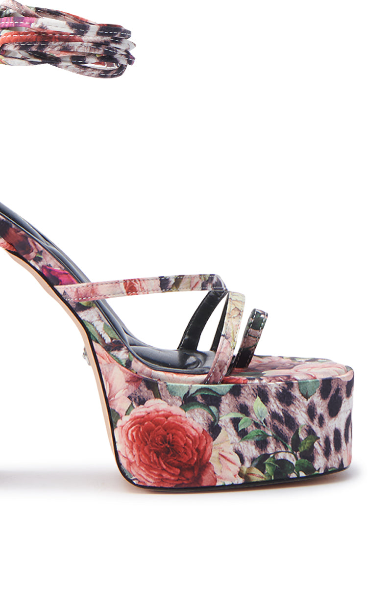 The AZALEA WANG BANIRA MULTI CHEETAH FLORAL CHUNKY SANDAL showcases a close-up design with an ankle strap, vibrant pink and beige floral leopard print platform and heel. The sleek, modern thin satin textile upper straps elegantly crisscross the foot.