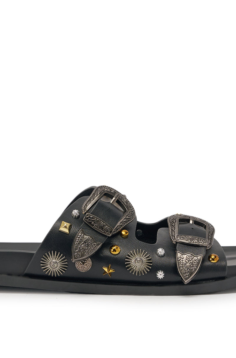 The AKIRA BARCLAY BLACK METAL EMBELLISHED SLIP ON FLAT SANDAL is a black faux leather slide with two ornate silver buckles and gold and silver star and sunburst studs for a bold, western-inspired look. 7