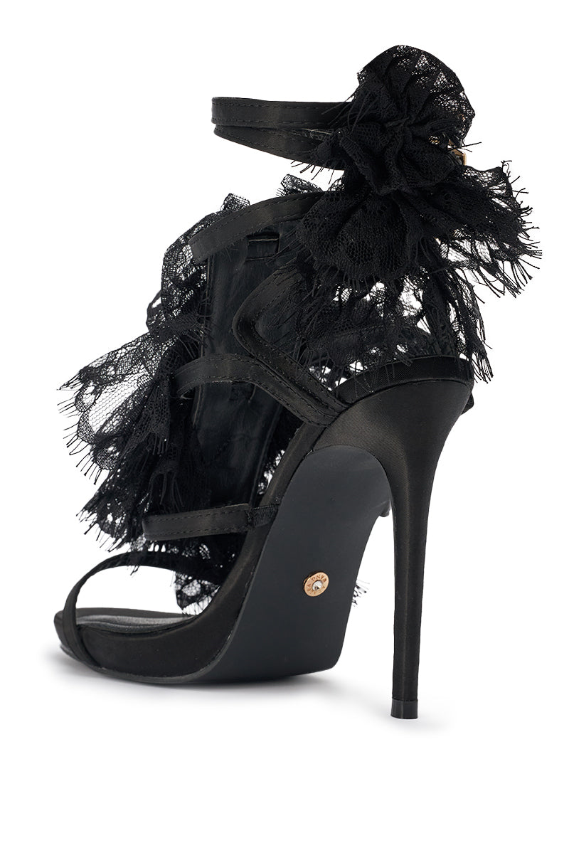 The AKIRA GOLD BARRISTER BLACK LACE DETAIL STILETTO SANDAL features black satin, delicate lace accents, an ankle strap, a side lace flower, open toe, and a stunning stiletto heel for an elegant finish. 5