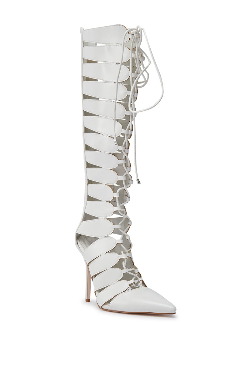 The AZALEA WANG BASTIAN WHITE BOOT features white faux leather, a knee-high shaft, pointed toe, open sides, and crisscross lace-up front on a sleek stiletto heel.