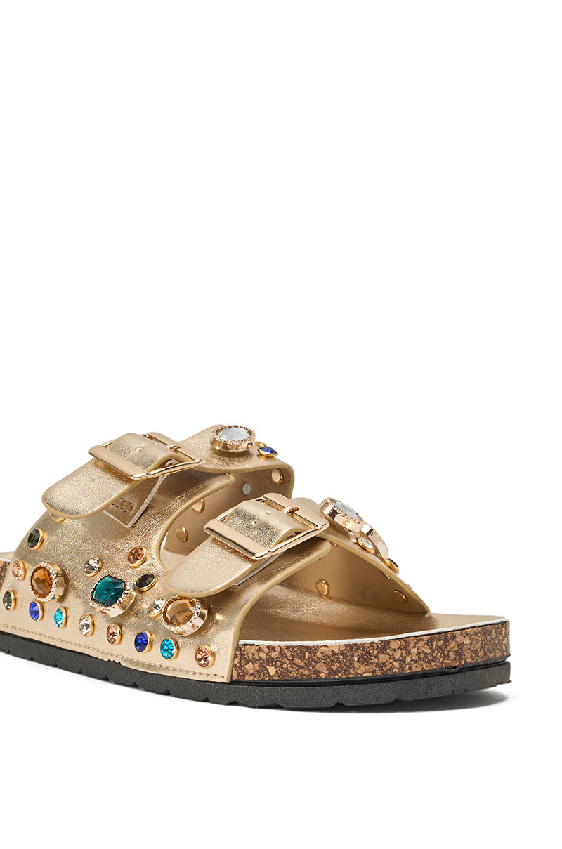 The AZALEA WANG BAYLEAVES GOLD EMBELLISHED SANDAL features gold faux leather, two buckled straps with jeweled accents, a cork midsole, and a black rubber sole—chic rhinestone slides for any occasion. 7