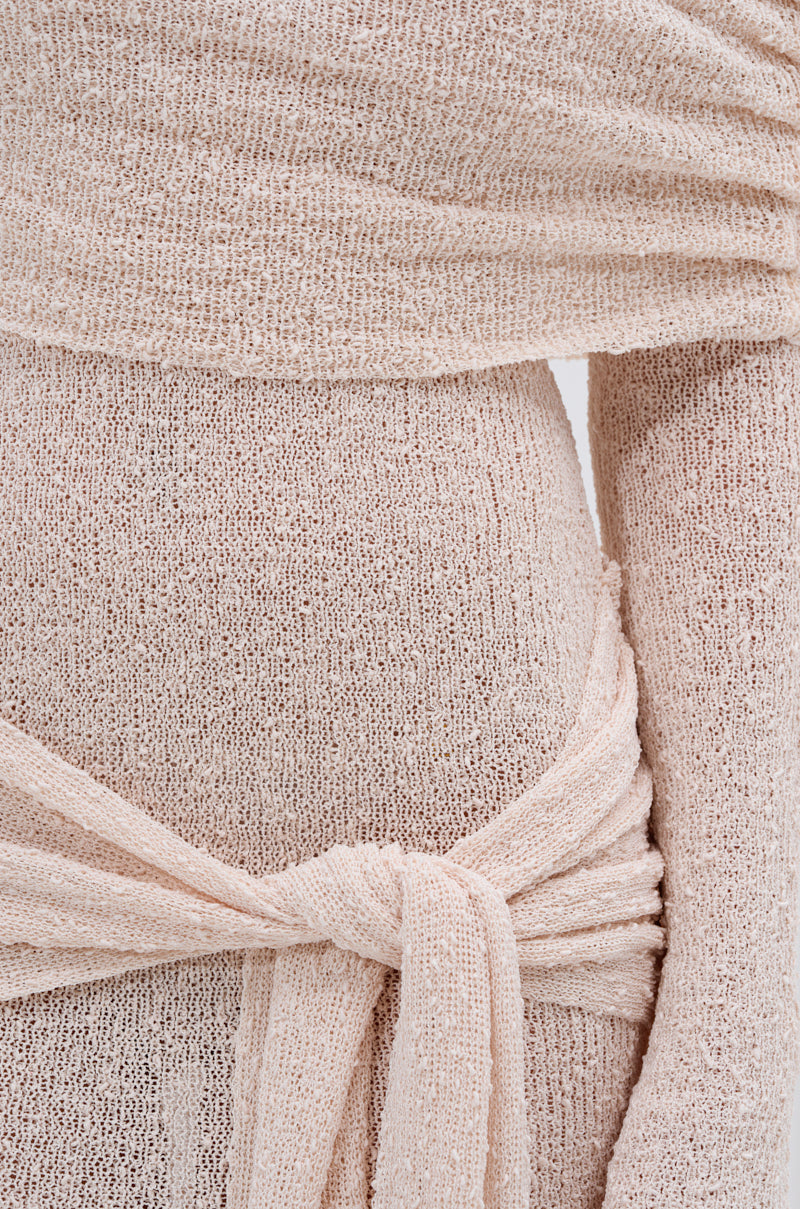 Close-up of the IN YOUR DREAMS KNIT MAXI DRESS in light beige, featuring a textured, lightweight knit, soft wrap design with a tie waist detail, and one arm exposed. The fabric is slightly sheer for an elegant look.