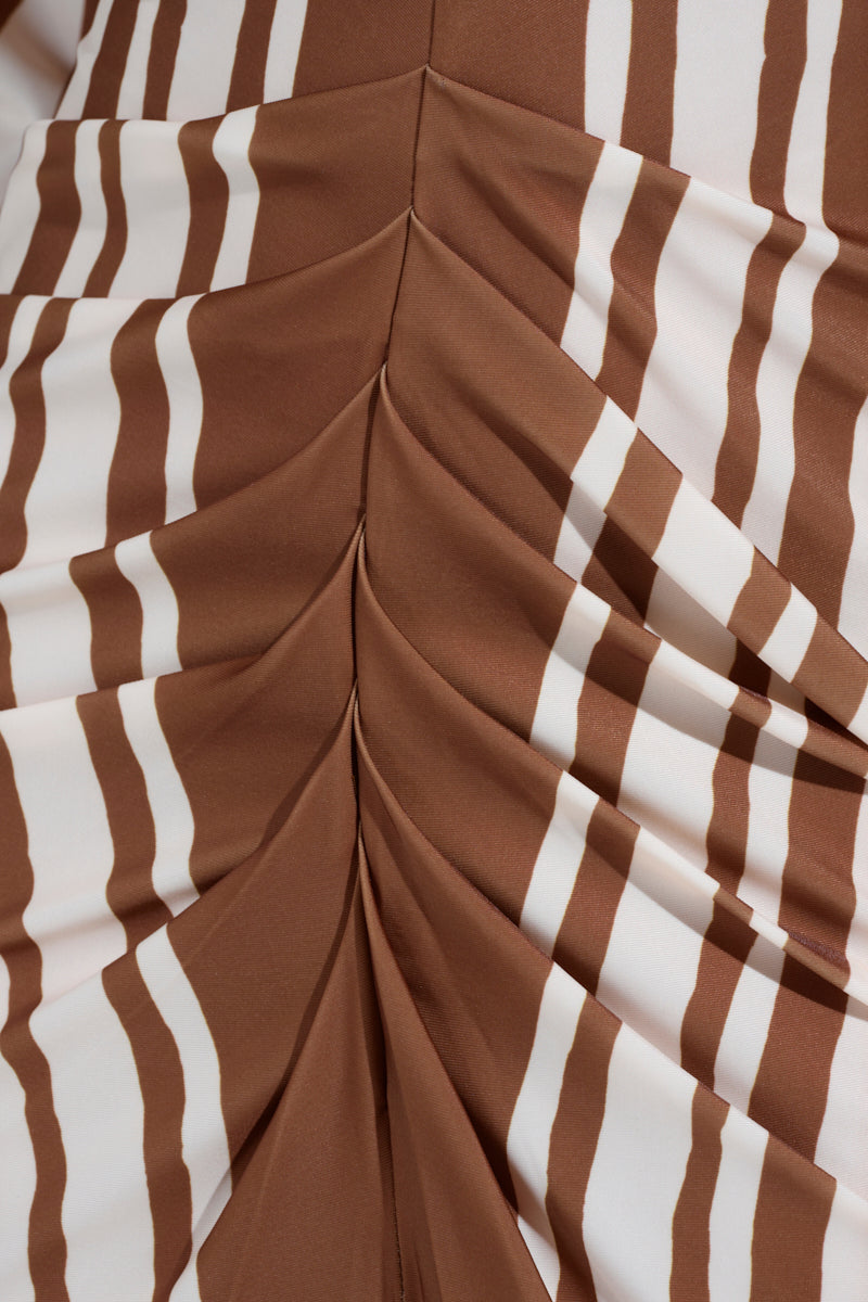 A close-up of the TEXT ME LATER SATIN MIDI DRESS featuring brown and white leaf-like striped patterns. The pleated fabric creates a ruched, textured, three-dimensional look.