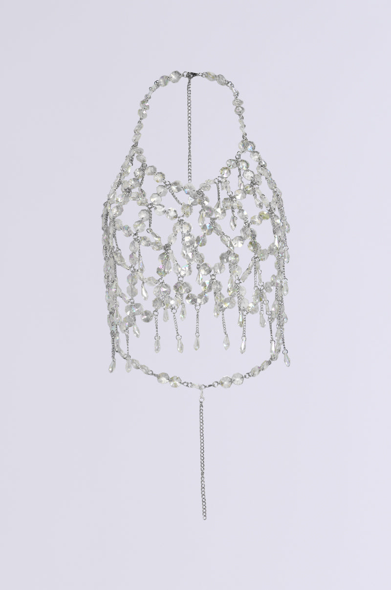 The FANTASY DROP RAZOR CRYSTAL BODY CHAIN TOP features a silver halter design made from interconnected chains and crystal-like beads, creating a geometric pattern ideal for a Y2K-inspired glam festival ensemble.