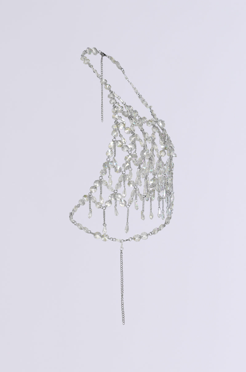 The FANTASY DROP RAZOR CRYSTAL BODY CHAIN TOP features a stunning design with silver chains and clear beads intricately woven in a web-like pattern. Perfect for achieving a glam festival look, it elegantly drapes with an elongated chain flowing down the center against a simple white background.