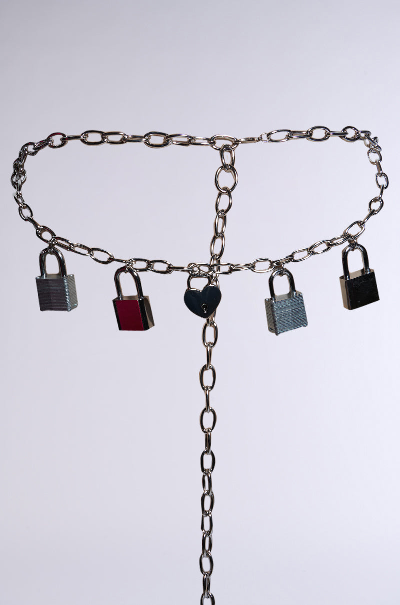 HEART ON LOCK CHAIN BELT showcases bold chain links, four silver padlock charms, and a central heart-shaped lock, all set against a simple light background. 3