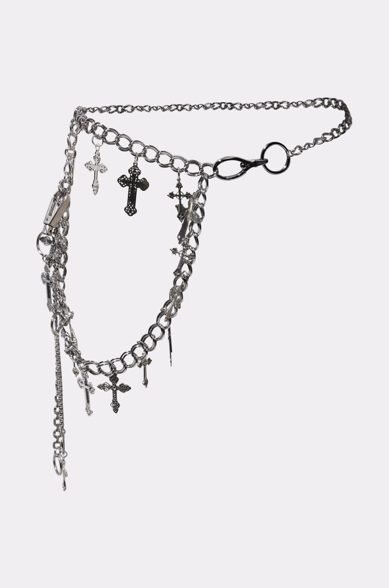 The ULTIMATE CROSS CHAIN BELT showcases layered silver chains with multiple dangling cross charms, set against a plain light background.