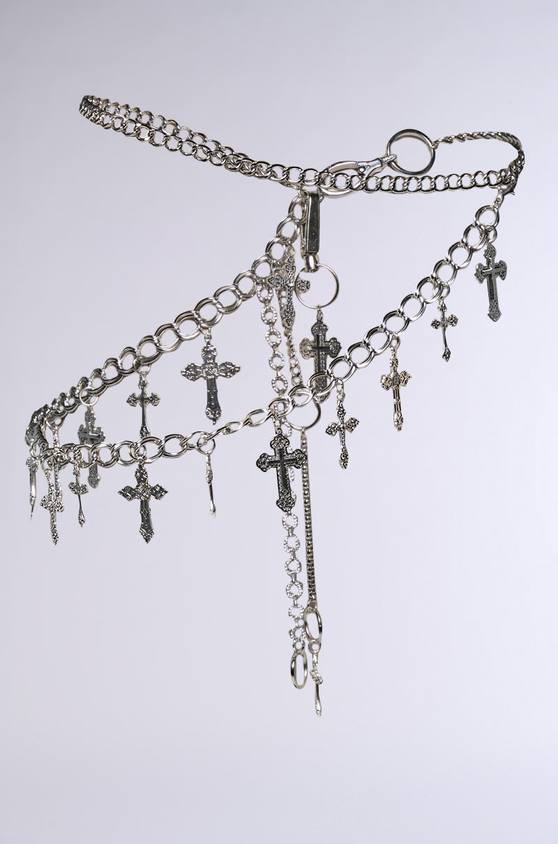 The ULTIMATE CROSS CHAIN BELT features multiple silver chains of varying thickness adorned with diverse cross pendants differing in size and design, creating a layered, intricate look perfect for festivals against a plain background.