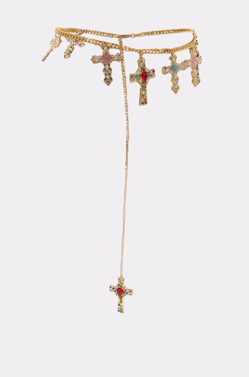 The IN MY FEELINGS CHAIN BELT features a gold chain adorned with dangling cross pendants embellished with red, green, and clear rhinestones. One jeweled cross hangs lower on a longer chain. Displayed on a plain white background. 2