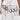 Only the lower torso and hand are visible as a person wears a white dress with black stitching, metallic studs, and the TEST MY LUCK HORSESHOE BELT featuring black and silver horseshoe pendants.