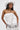 A woman with long straight hair and large hoop earrings poses in a strapless white dress and cowboy hat, accessorized with the TEST MY LUCK HORSESHOE BELT for a Western-inspired look.
