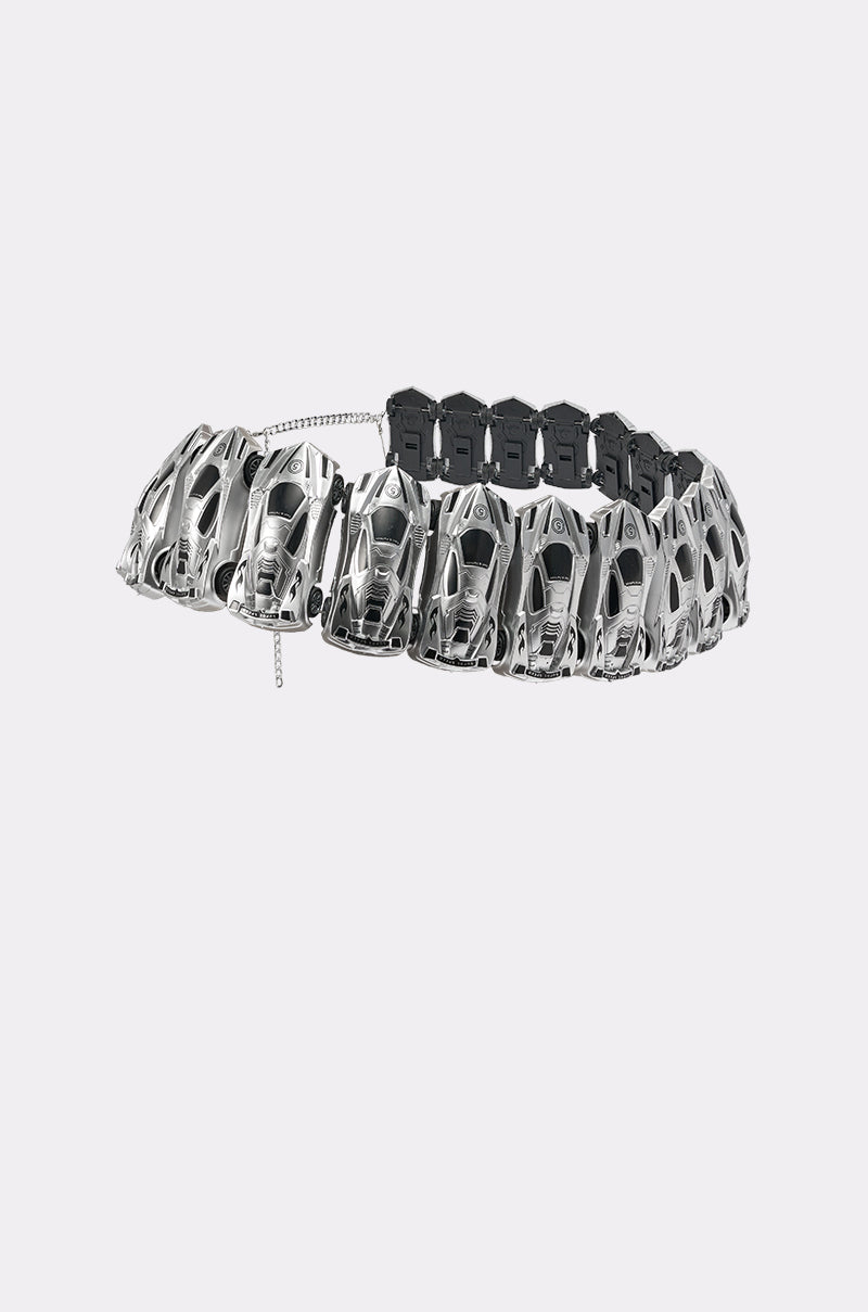 The VROOM VROOM CAR BELT features chrome-finished miniature sports cars linked over a black band with a small clasp chain, channeling Y2K streetwear vibes. Displayed on a plain, light gray background.