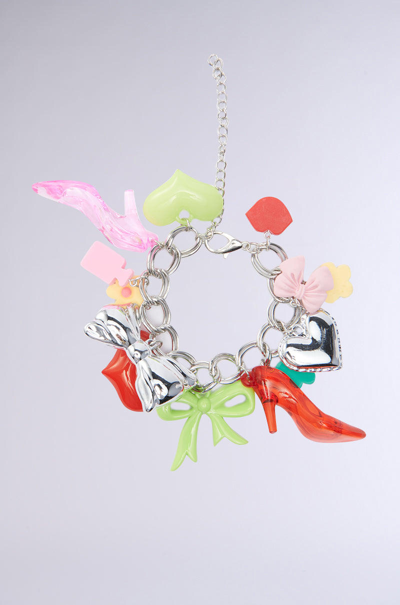 Make a bold statement with the CHARM LIFE BRACELET—chunky silver links detailed with Y2K-inspired charms like a high-heeled shoe, bow, heart, leaf, butterfly, and flower—set against a light gray background.