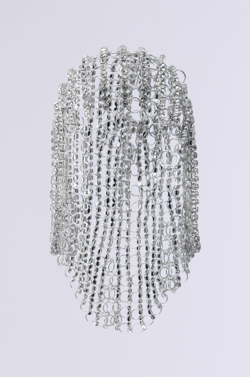 The QUEEN SH*T BLING HEADPIECE features interlinked silver rings and rhinestone chains that form a draped, mesh-like structure against a plain backdrop.