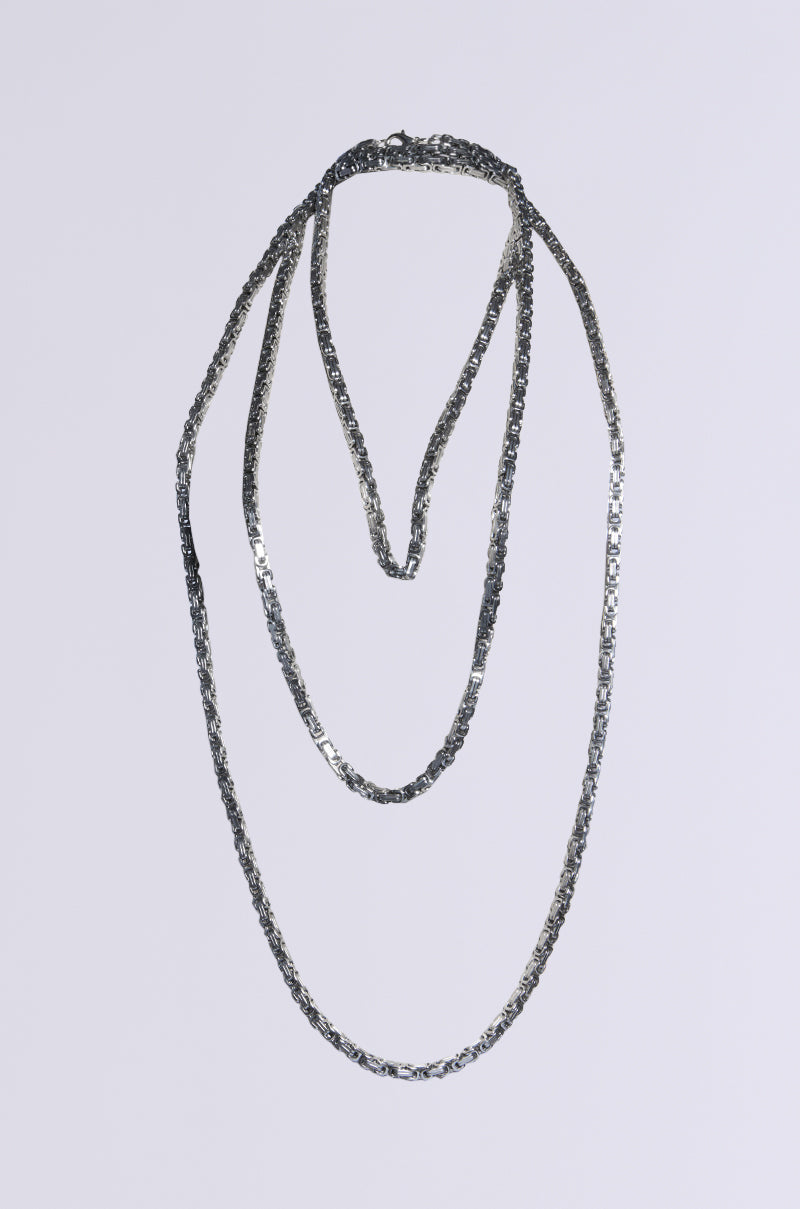 The POP THE TAB LAYERED CHAIN is a textured silver necklace with multiple long chains that cascade elegantly against a plain white background.