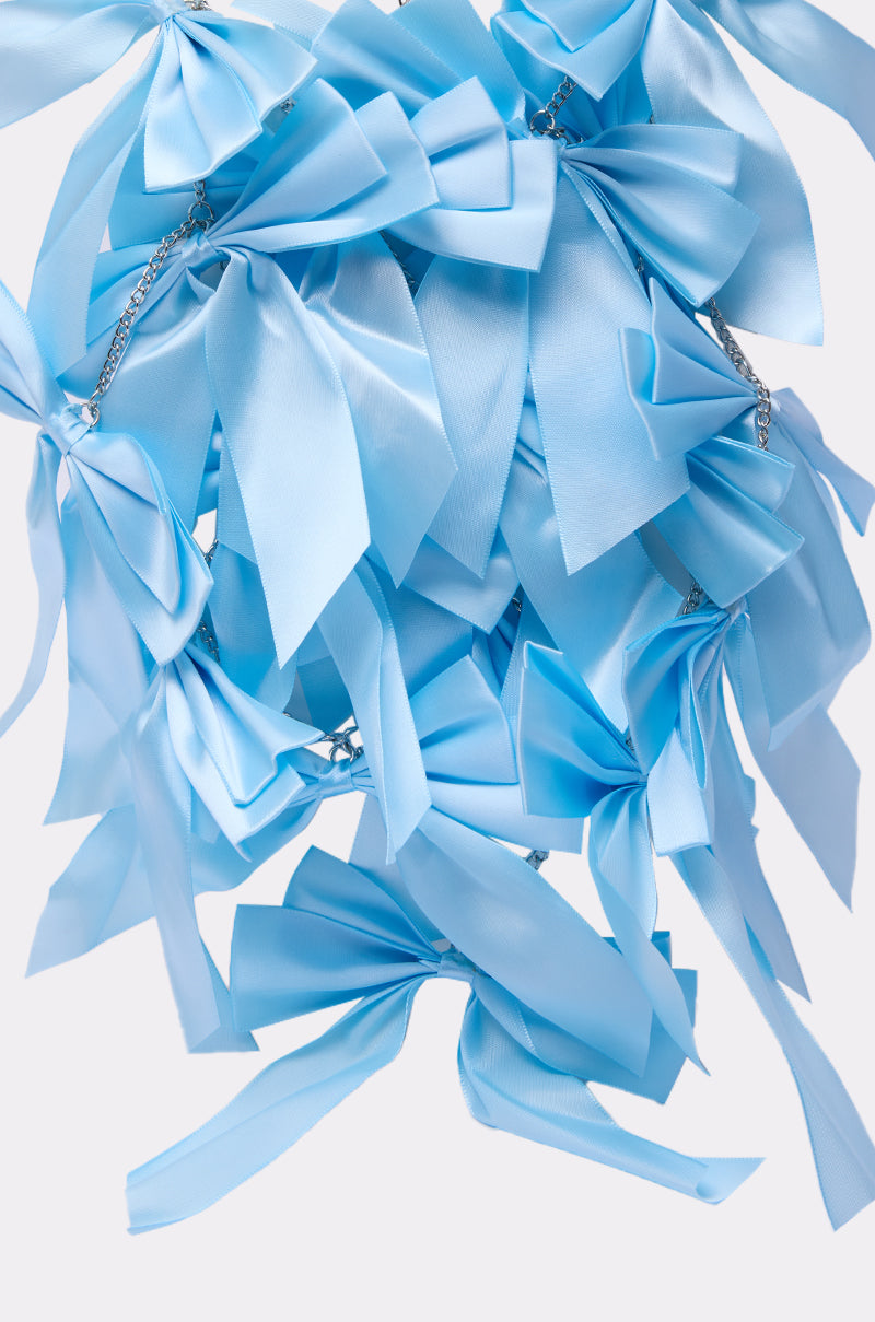 The FEMME BOW STATEMENT NECKLACE features large, shiny light blue satin bows clustered together with hints of silver chains, creating a bold feminine look against a plain white background.