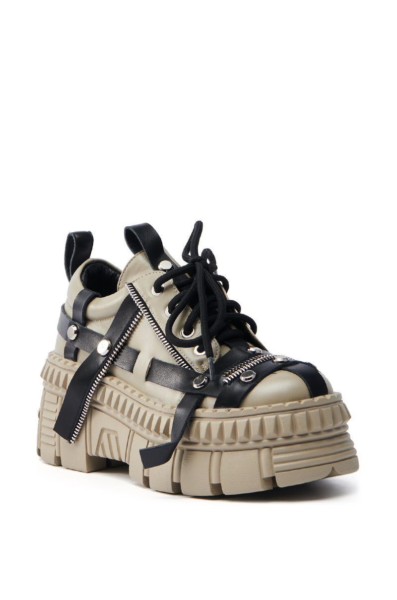 The AZALEA WANG BEAGLE KHAKI FLAT SNEAKER is a chunky sneaker with a beige and black design, featuring a flatform lug sole, black leather straps, laces, and zipper detailing. Its rugged, futuristic appearance is enhanced by the thick, textured sole.