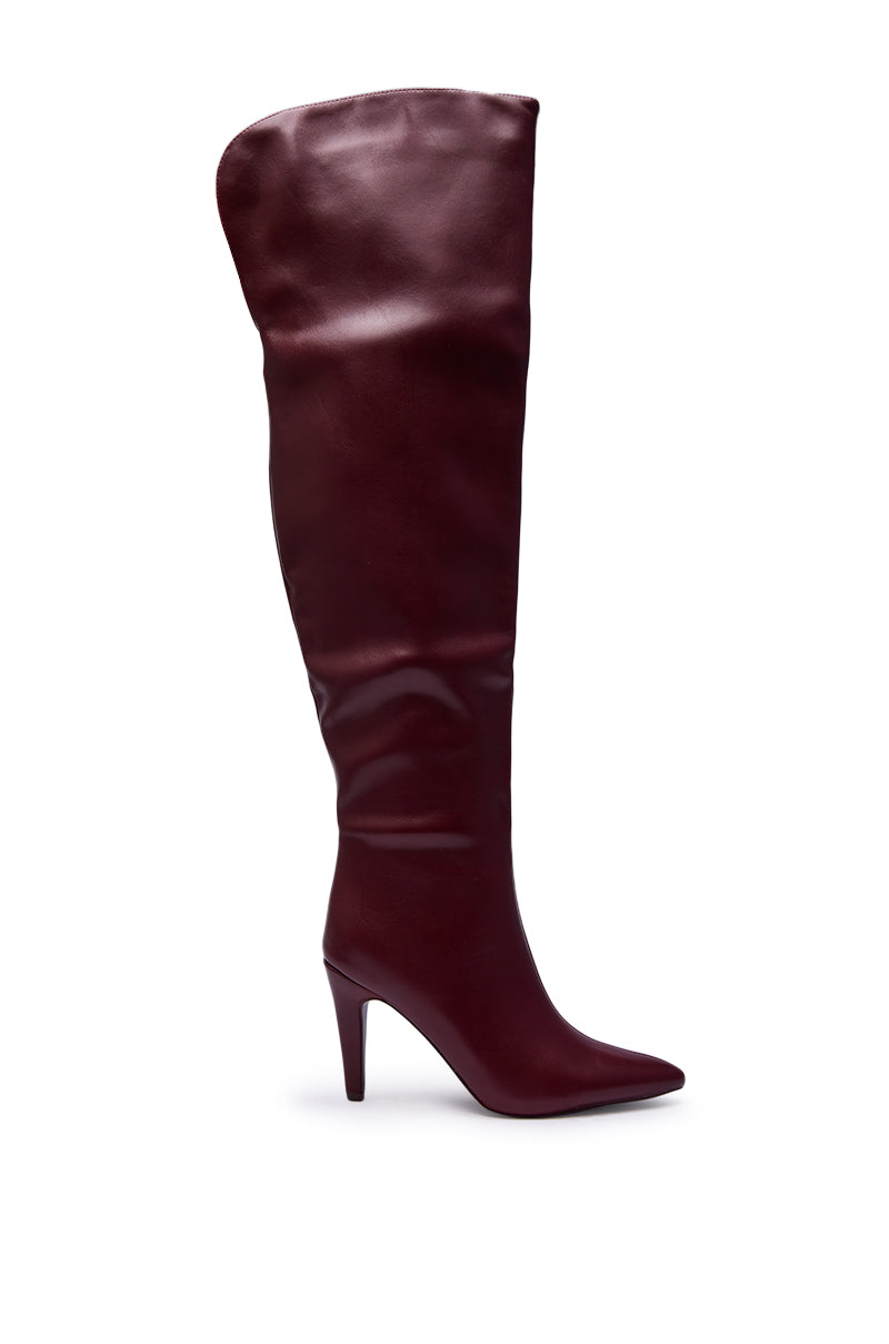 The AZALEA WANG BEAUCOUP BURGUNDY OVER THE KNEE BOOT features dark burgundy leather, a high stiletto heel, and a pointed toe, displayed in profile against a white background.