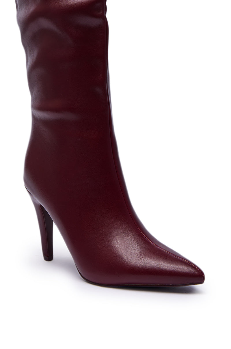 A close-up of the AZALEA WANG BEAUCOUP BURGUNDY OVER THE KNEE BOOT, featuring a pointed toe and sleek stiletto heel in rich faux leather, shown against a white background.