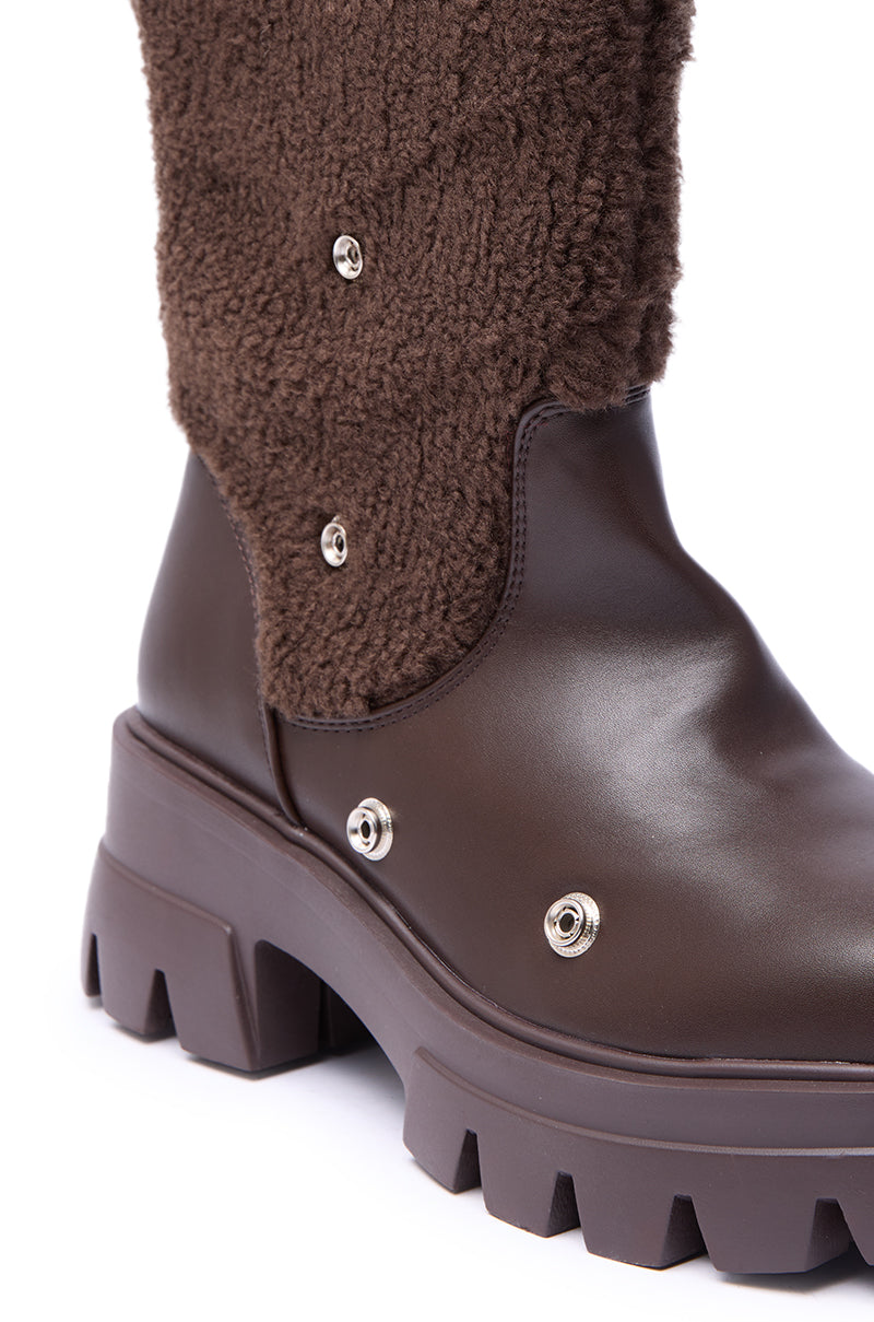 Close-up of the AZALEA WANG BEHATI BROWN SHERPA BOOTIE WITH SNAP DETAIL, featuring a chunky heel, textured faux sherpa upper, smooth leather lower section, and metallic snap buttons for added style.
