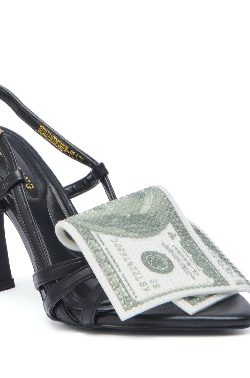 The AZALEA WANG BENJAMINS BLACK NEW MONEY SANDAL is a black faux leather stiletto heel sandal featuring a front strap adorned with a folded $100 bill-like decorative detail.