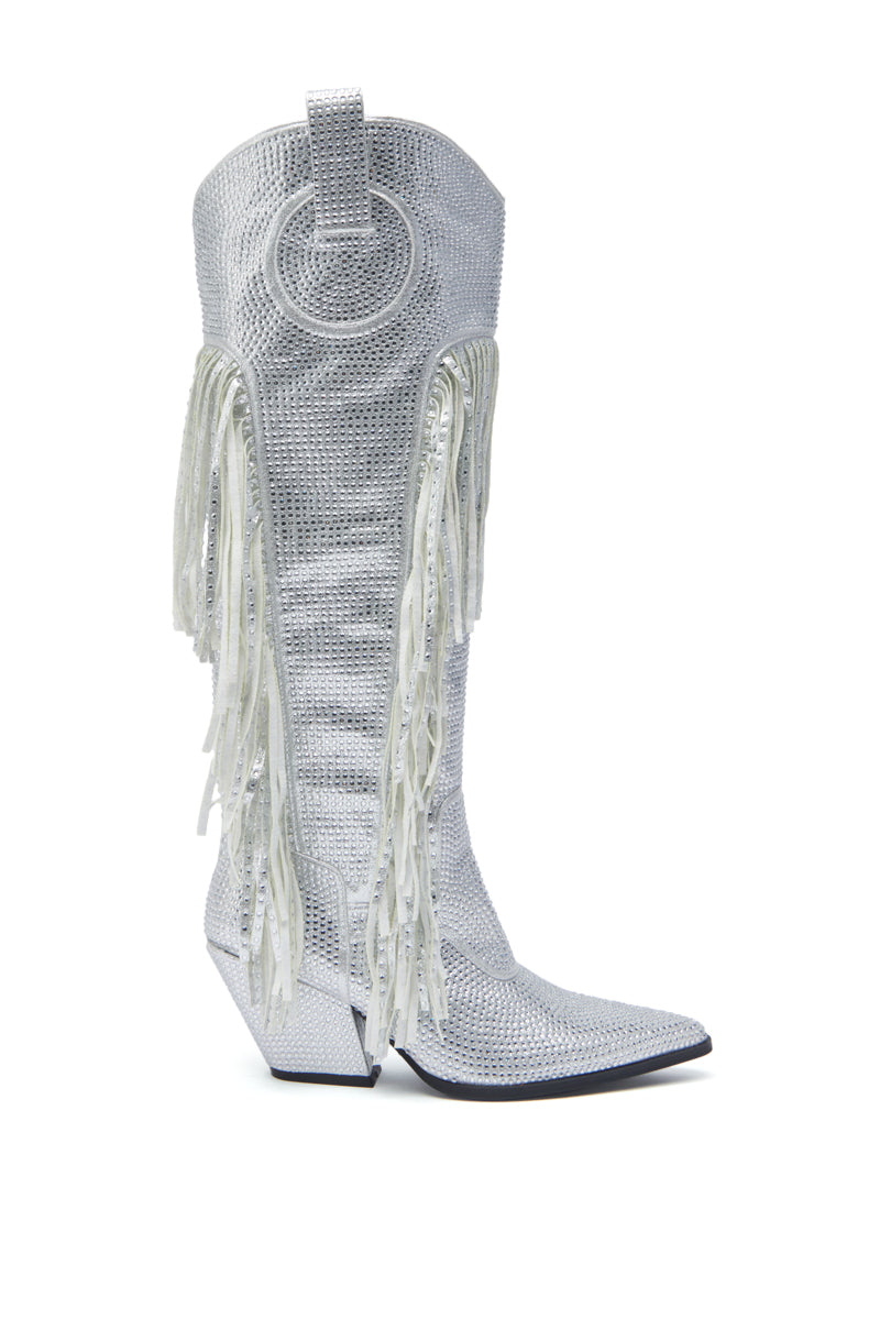 The AZALEA WANG BENNETTO SILVER RHINESTONE WESTERN BOOT is a tall, knee-high silver boot with a textured finish, white fringe sides, circular pull tab, pointed toe, and angled heel shown against a white background.