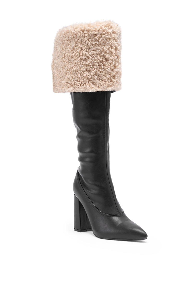 The AZALEA WANG BENOUL BLACK SHERPA LINED CHUNKY BOOT features a pointed toe, smooth leather-like finish, block heel, and knee-high fit with a thick, folded-over beige shearling cuff for added style and warmth.
