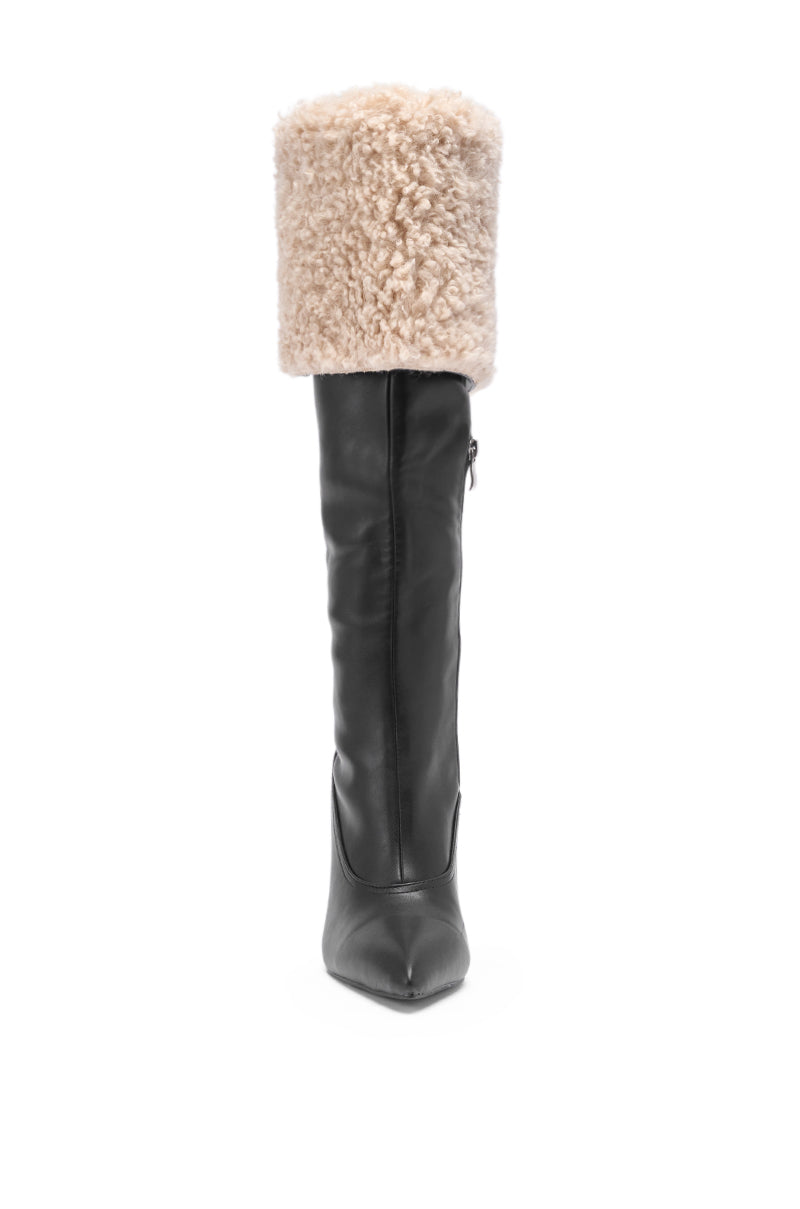 The AZALEA WANG BENOUL Black Sherpa Lined Chunky Boot is a tall, knee-high faux leather boot with a pointed toe and a thick, folded-over beige shearling cuff, displayed against a white background.