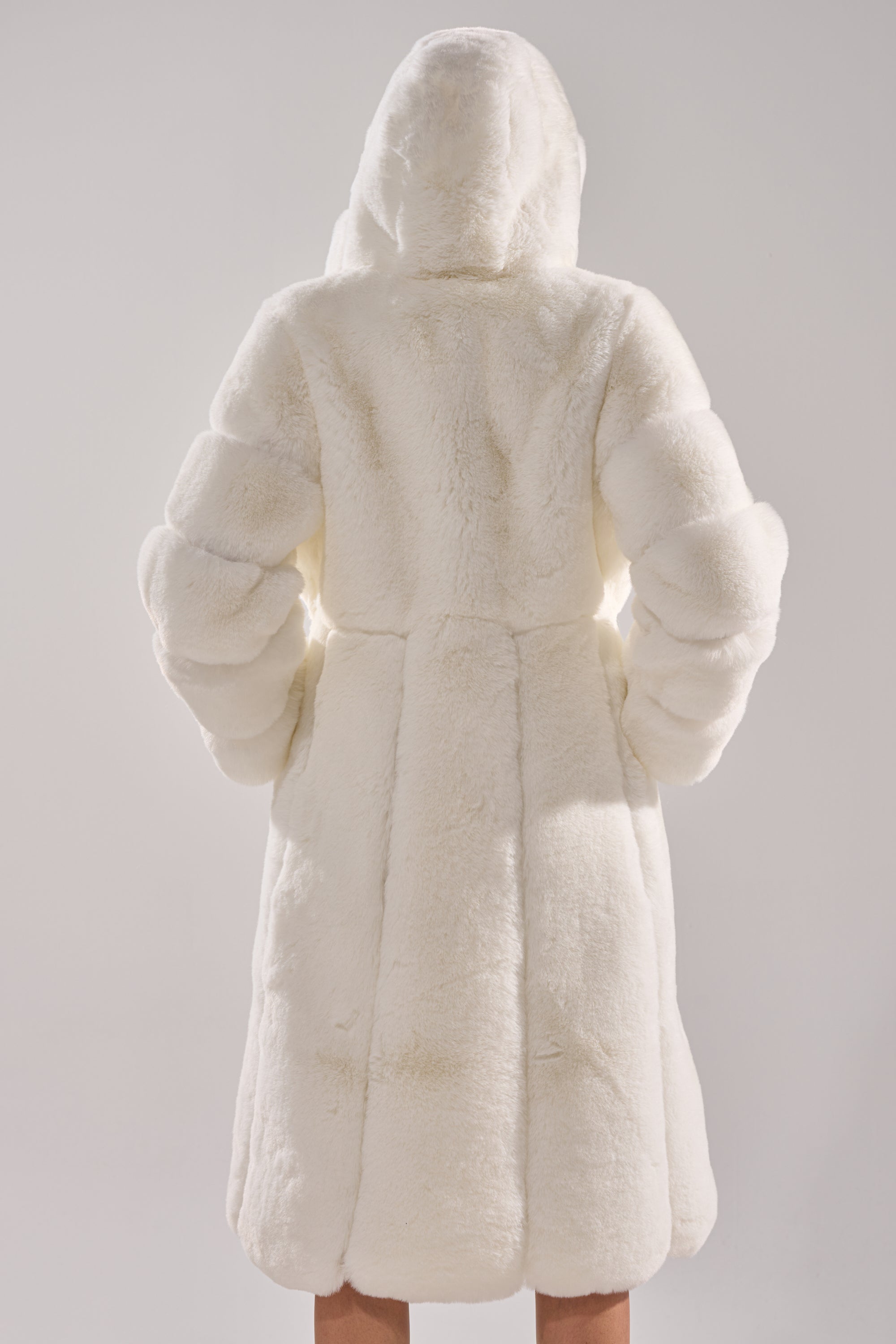 A person is shown from the back against a plain light background, wearing the BERLIN HOODED FAUX FUR IN WHITE.
