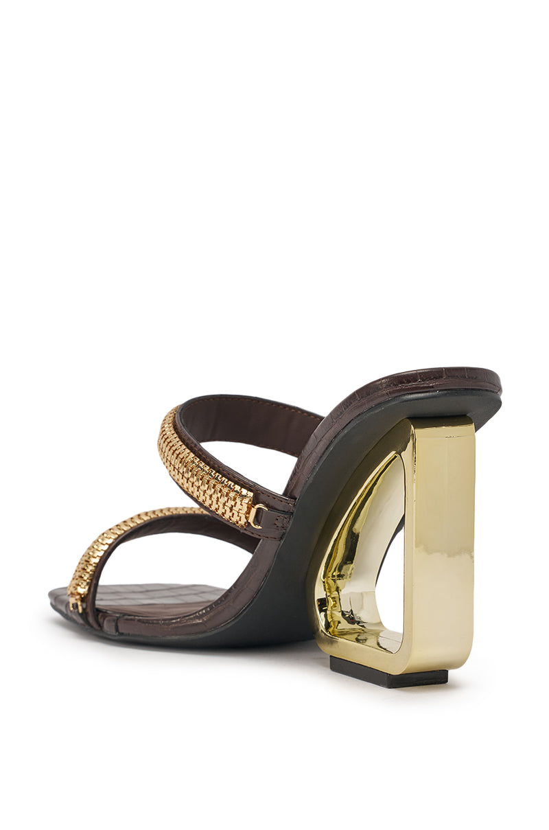 The AZALEA WANG BESSIE CHOCOLATE CROC GOLD EMBELLISHED WEDGE SANDAL features brown croc-embossed faux leather, gold-hardware straps, and a geometric gold heel, shown from the back against a white background. 6