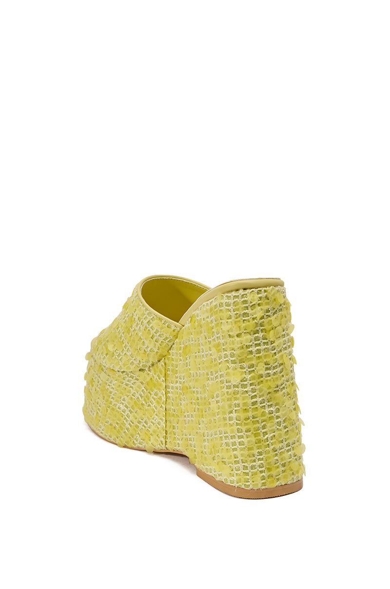 The AZALEA WANG BETSEY YELLOW SEQUIN RAFFIA WEDGE is a lemon-lime textured slip-on with a chunky heel and subtle sequin accents, displayed from a rear side angle on a white background. 6