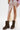 A person wears a sheer cream lace skirt with high slits and the AZALEA WANG BHARTI BROWN FLAT BOOTIE. Part of a multicolored plaid shirt is visible at the top, set against a plain white background.