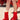 Wearing the AZALEA WANG BHARTI RED SNAP DETAIL BOOTIE, a person with white socks with yellow stripes sits on a red picnic bench outdoors; only their legs and feet are visible.