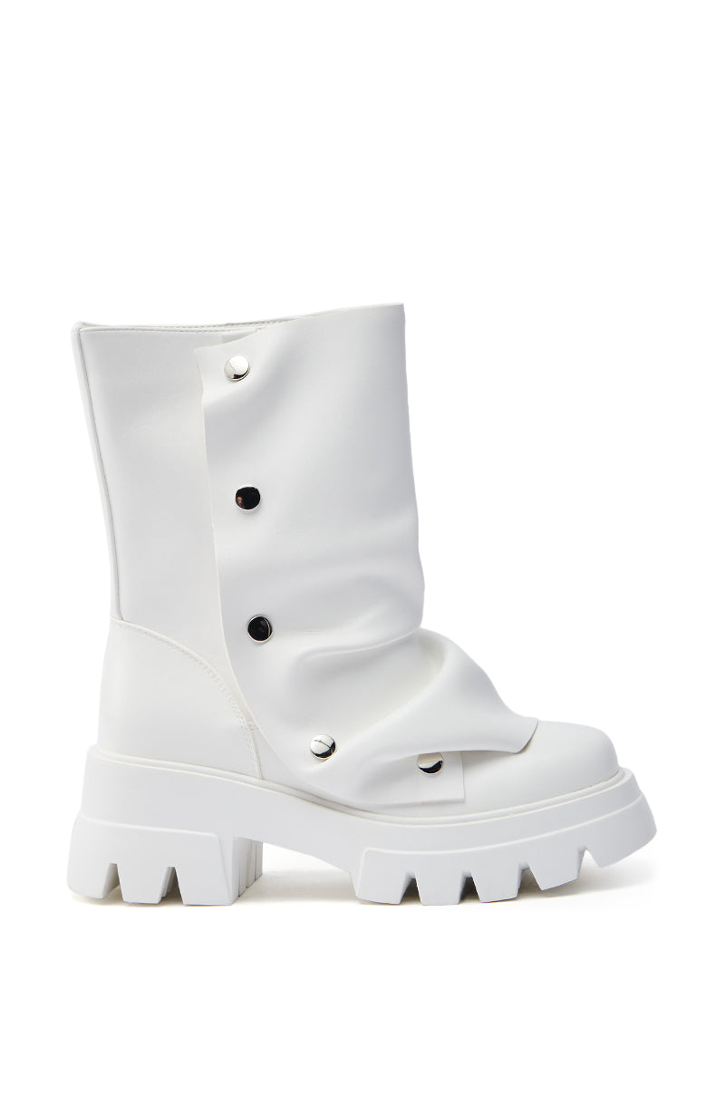 The AZALEA WANG BHARTI WHITE SNAP BOOTIE is an oversized, white boot made from vegan leather with a chunky, ridged sole. Its slouchy design includes black snap accents on the side for a modern and stylish look.