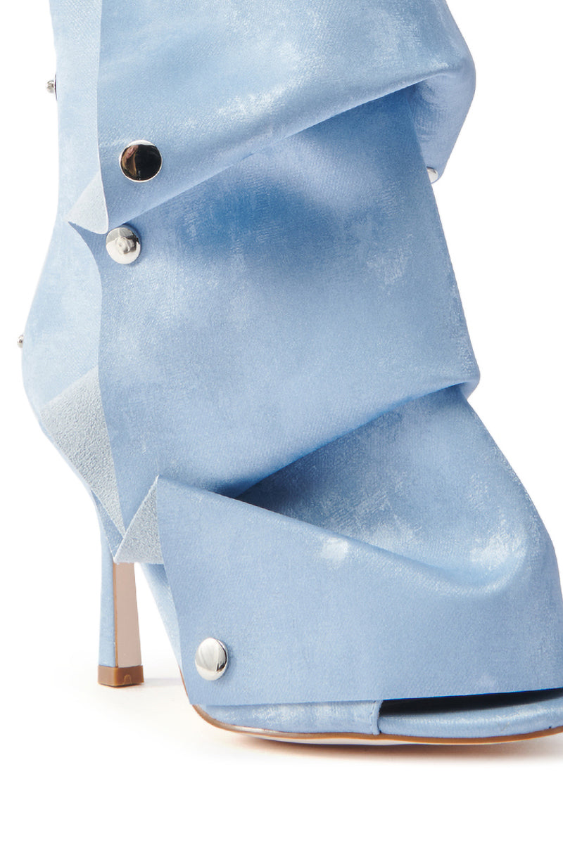 Close-up of the AZALEA WANG BIRD SONG SNAP OPEN TOE BOOTIE in light blue with a unique fabric design. The textile upper has a folded texture secured by metallic buttons and elegant stiletto heel.