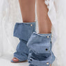A person wears AZALEA WANG BIRD SONG DENIM OPEN TOE SNAP BOOTIE styled with a white sheer skirt featuring floral appliqués.
