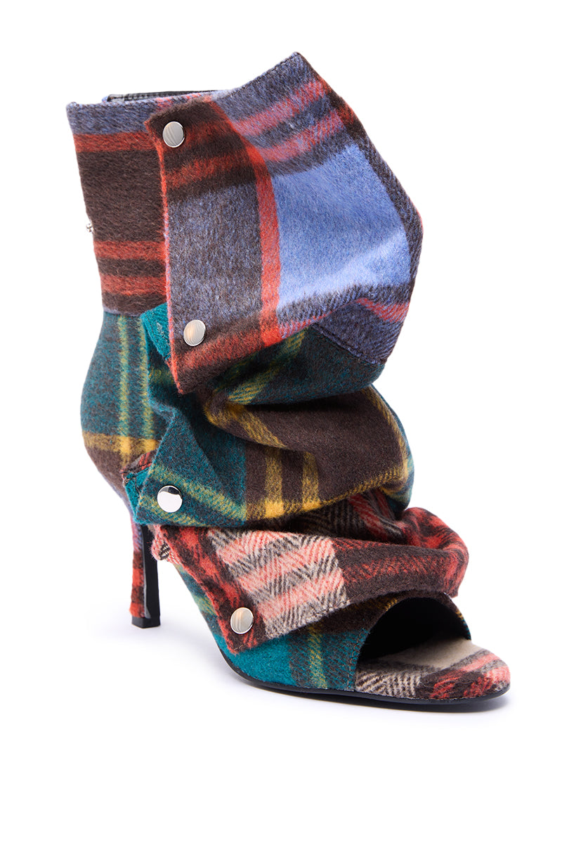 The AZALEA WANG BIRD SONG PLAID MULTI OPEN TOE SNAP BOOTIE features a high heel, open toe, vibrant multicolored plaid fabric, layered design, and stylish silver button accents.