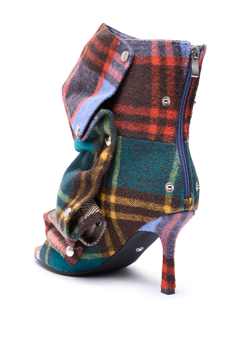The AZALEA WANG BIRD SONG PLAID MULTI OPEN TOE SNAP BOOTIE features a multicolored plaid pattern, silver snap buttons, blue side zipper, stiletto heel, open toe, and draped fabric design.