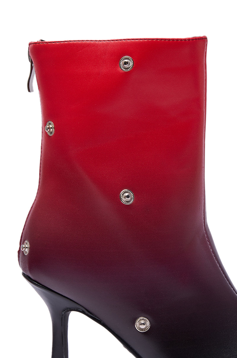 A close-up of the AZALEA WANG BIRDSONG RED OMBRE SNAP OPEN TOE BOOTIE, showcasing a red ombre finish, high stiletto heel, metallic studs, and a visible back zipper.