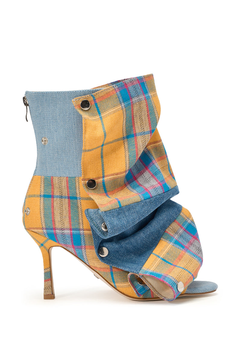 The AZALEA WANG BIRDSONG YELLOW PLAID SNAP BOOTIE is a high-heeled, open-toe stiletto bootie crafted from yellow plaid and blue denim with silver grommets and a ruched snap panel for a bold, fashion-forward look. 2