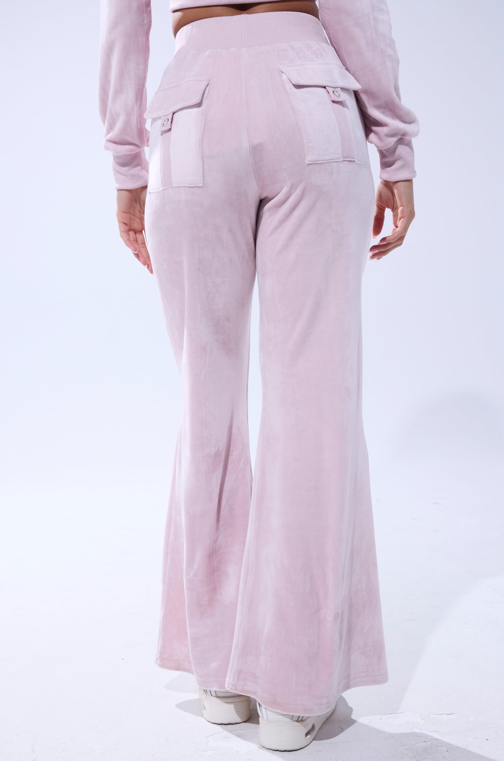 A person is seen from behind wearing the TAYLOR STRAIGHT LEG JOGGER IN PINK with a matching top and white shoes. The high-rise joggers have flap back pockets, and the look is set against a plain white background. 5