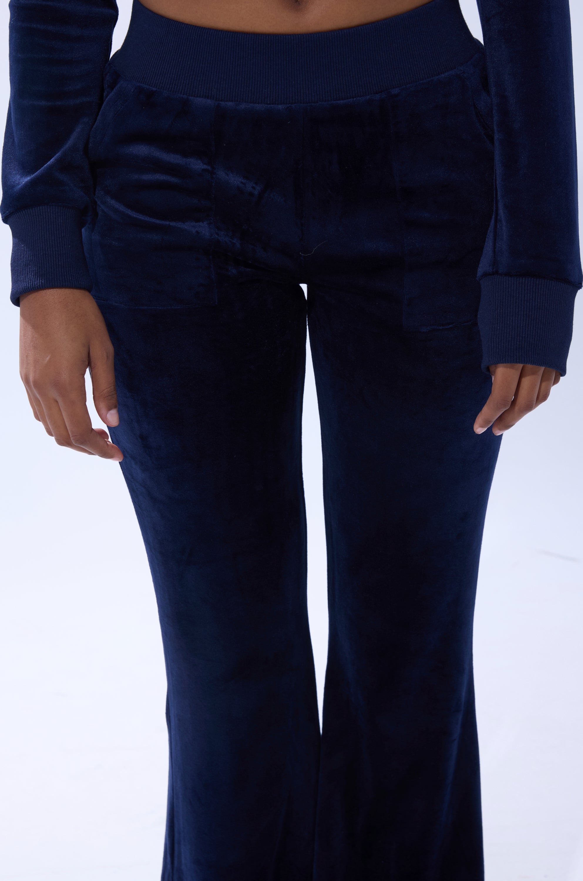 A person wearing the TAYLOR STRAIGHT LEG JOGGER IN NAVY, shown from mid-torso to feet with hands by their sides, highlights the comfortable and stylish lower half of this navy blue jogger outfit. 6