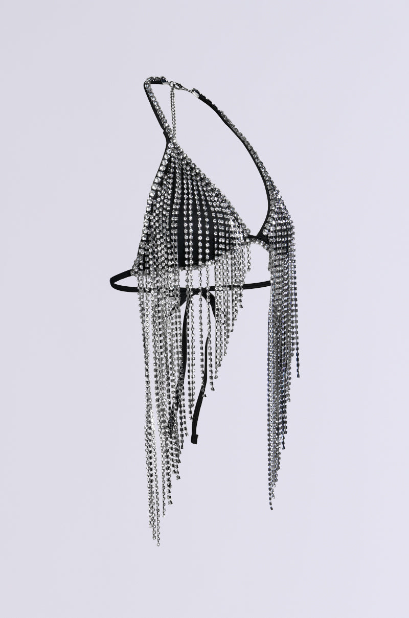 The BRING THE FUN RHINESTONE FRINGE BRALETTE TOP features a black triangle design embellished with cascading silver rhinestone chains that provide a shimmering fringe effect. Ideal for any party, the piece is presented against a plain light gray background.