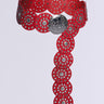 The ROSES ARE RED CIRCLE BELT is a Western-inspired decorative belt in red faux leather with multiple circular sections featuring silver details, and a prominent silver medallion at the front. It has an elongated design forming a T-shape.