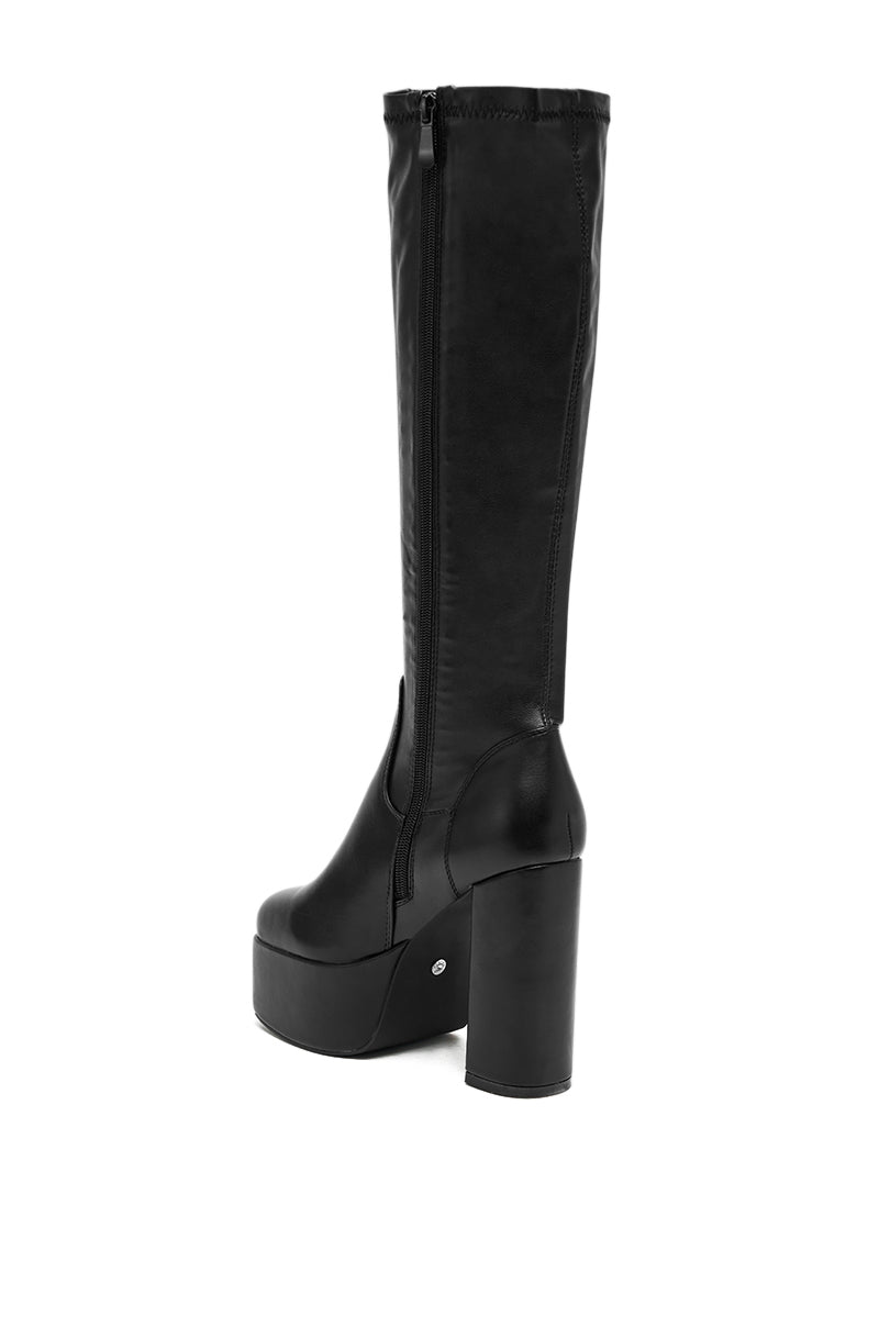 The AZALEA WANG BOMBON BLACK STRETCH PU CHUNKY BOOT is a knee-high boot made from premium black stretch faux leather, featuring a sleek chunky heel for a modern, chic look. 4