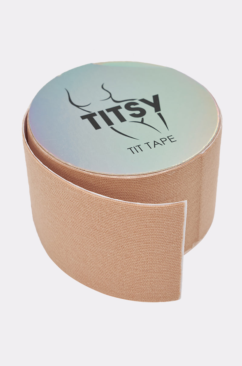 A roll of TITSY ULTRA LIFT BOOB TAPE IN LIGHT, partially unrolled on a white background, with a holographic lid featuring a minimalist bust outline. This tape provides invisible support in a beige nude shade. 0