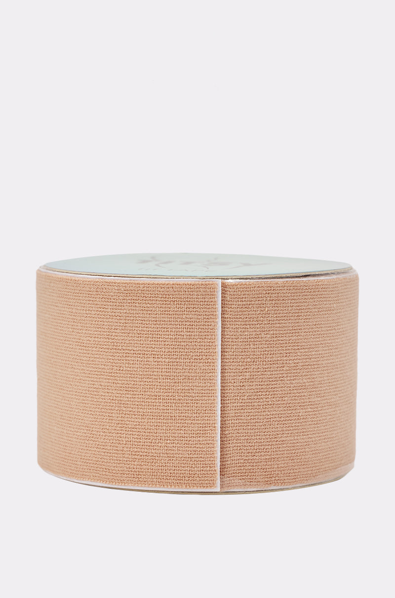A roll of TITSY ULTRA LIFT BOOB TAPE IN LIGHT, featuring smooth beige elastic fabric for invisible support, stands upright against a plain white background. 1